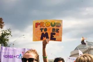 An Equality March participant with a poster "Proud to be me"