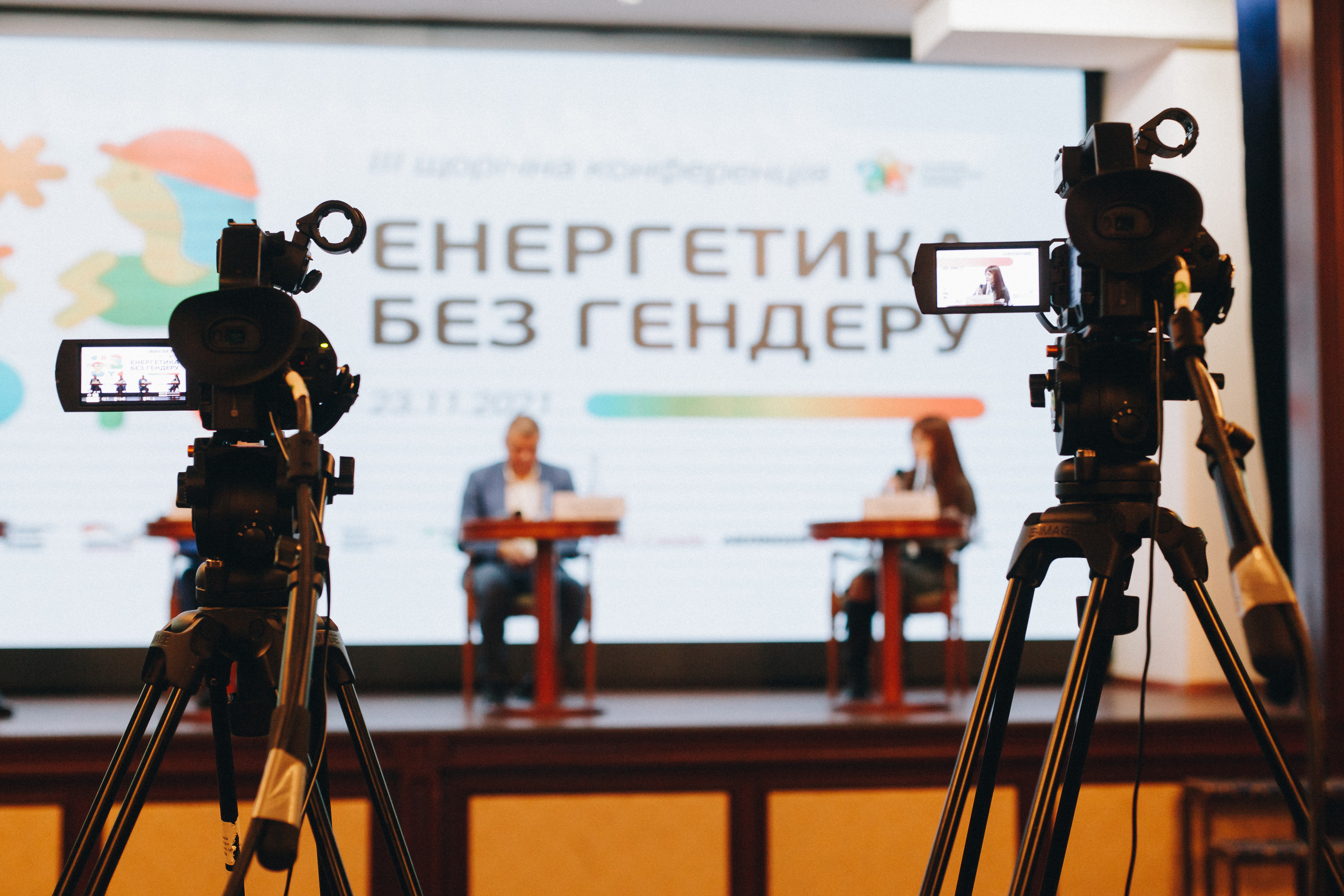 Камери, спрямовані на вивіску з назвою конференції