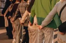 Люди тримаються за руки за спинами