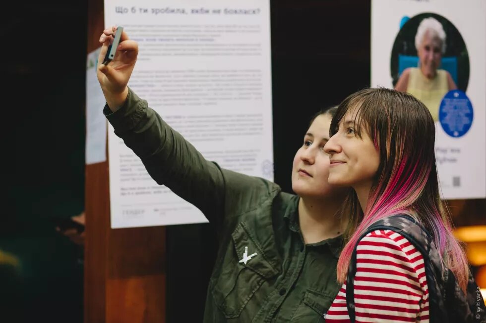 Event participants taking a selfie in front of the photo project