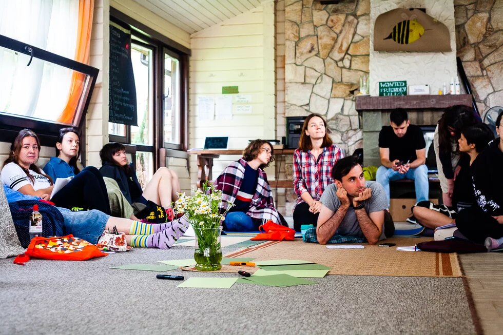 Participants of Green Academy 2019 are sitting or lying on sleeping mats and listening to a lecture