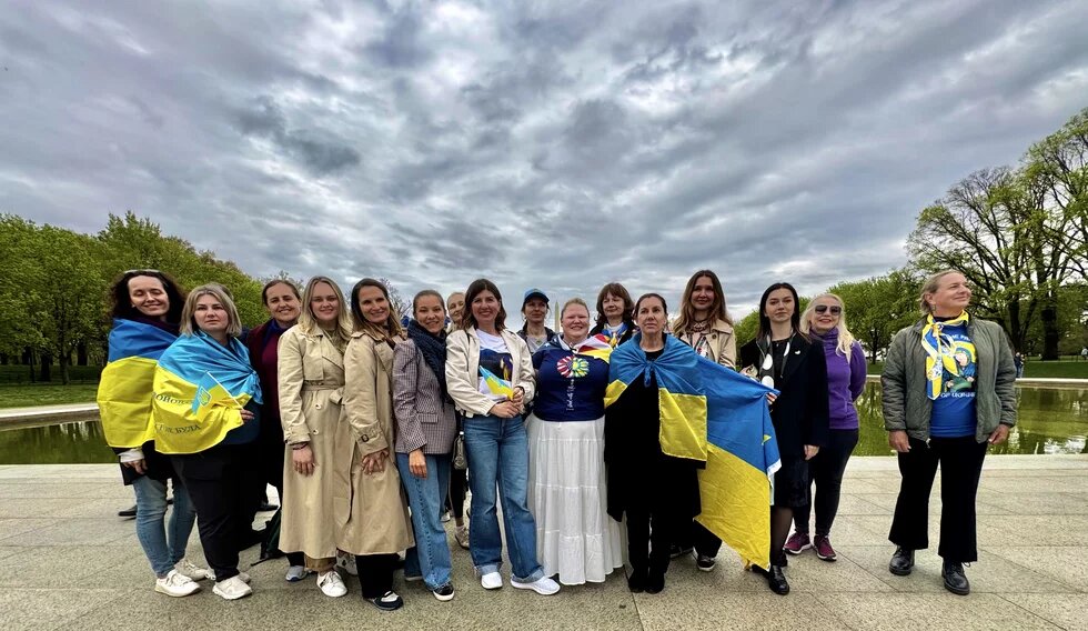 Колективне фото жінок з українськими прапорами 